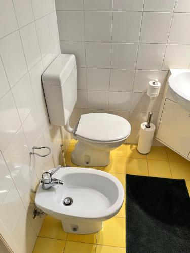 a bathroom with a white toilet and a sink at Rifugio Rustico con Vista sulle Colline Toscane in Settignano