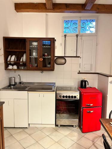 a kitchen with a red stove and a red refrigerator at Rifugio Rustico con Vista sulle Colline Toscane in Settignano