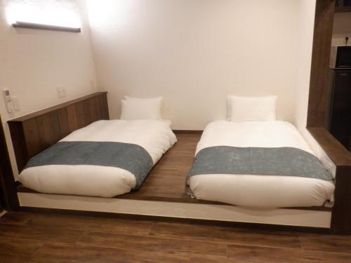 two beds sitting next to each other in a room at 風の音 in Motobu