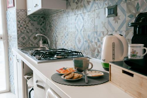 una cocina con fogones y un plato de comida en Le Case delle Rose, en Civitavecchia