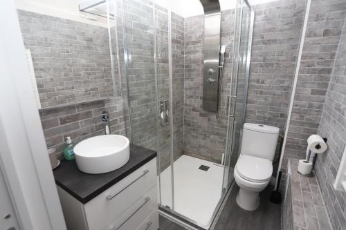 une salle de bain avec toilettes, lavabo et douche dans l'établissement Moderne et lumineux appart face à la mer,, à Saint-Cyprien