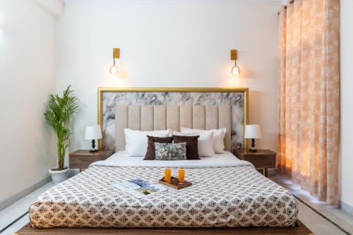 a bedroom with a large bed with two candles on it at Homlee-Green Luxury 3BHK-South DEL-NFC-Fortis Hospital in New Delhi