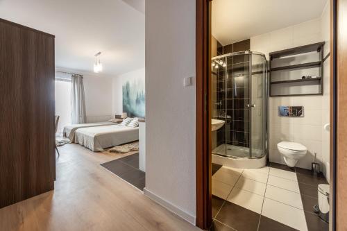 a bathroom with a shower and a bedroom with a bed at Gabrysia in Bukowina Tatrzańska