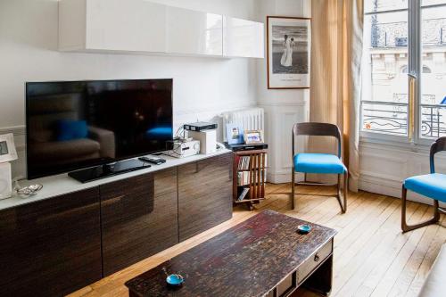 un salon avec une grande télévision à écran plat dans l'établissement Charming and bright near Montmartre, à Paris