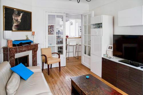 un salon avec un canapé blanc et une cheminée dans l'établissement Charming and bright near Montmartre, à Paris