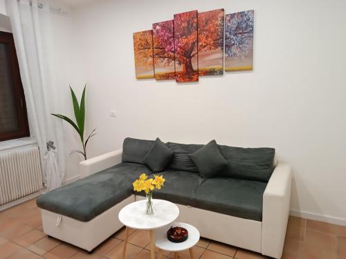 a living room with a couch and paintings on the wall at La Casa Vacanze di Byron in Gorizia