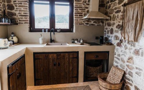 a kitchen with a sink and a window at Μάραθος in Kalavrita