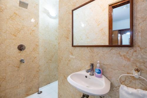 a bathroom with a sink and a shower and a mirror at Homlee-Green Luxury 3BHK-South DEL-NFC-Fortis Hospital in New Delhi
