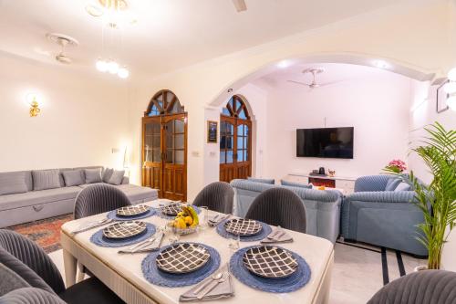 a living room with a table and chairs at Homlee-Green Luxury 3BHK-South DEL-NFC-Fortis Hospital in New Delhi