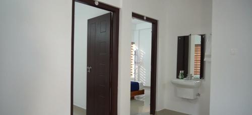 a bathroom with a mirror and a toilet and a sink at Smile Residency in Sultan Bathery