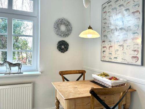 a dining room with a wooden table and a window at Romantikhaus am Hafen in Greetsiel in Greetsiel
