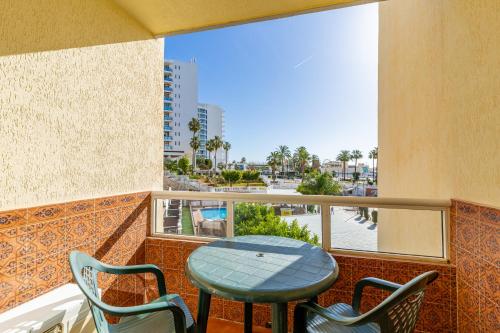 einen Tisch und Stühle auf einem Balkon mit Stadtblick in der Unterkunft Apartamentos Tamarindos in Benalmádena