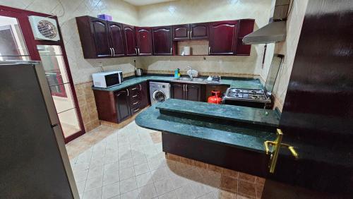 a kitchen with purple cabinets and a stove top oven at Fabulous Villa Rooms near Airport in Dubai