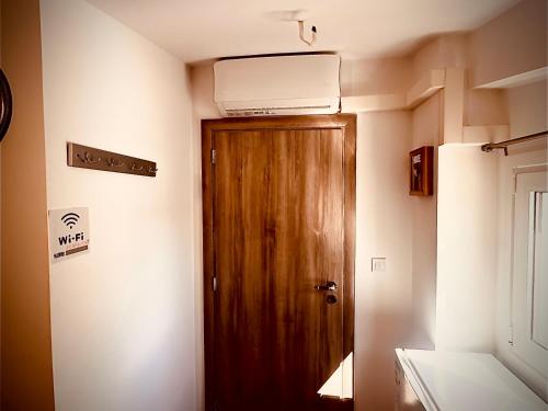 a room with a wooden door and a air conditioner at Airport Sea View - Studio in Artemida