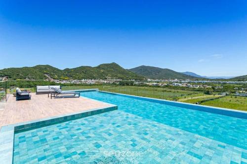 a swimming pool with a view of the mountains at Studios aconchegantes em Floripa - OKA in Florianópolis