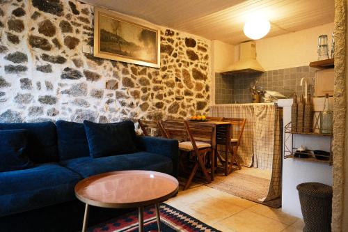 a living room with a blue couch and a table at CASA MIA - Maison et chambres à louer à Corbara in Corbara