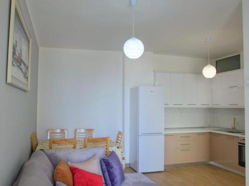 a living room with a couch and a kitchen at Deluxe Apartments Shengjin in Shëngjin