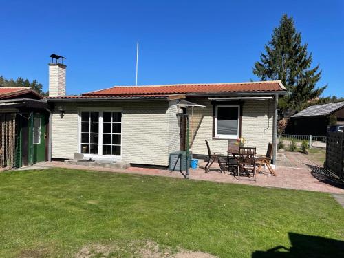 リーブニッツ・ダムガルテンにあるFerienhaus am Küstenwaldの庭のテーブルと椅子付きの家