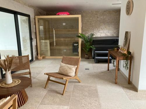 a living room with a couch and a table and chairs at Domaine du lion rouge Piscine et Spa in Coucy-le-Château-Auffrique