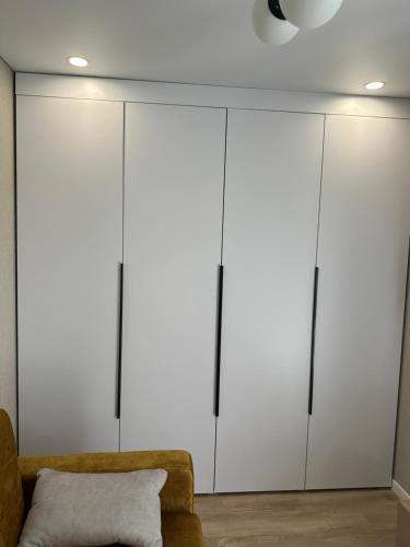 a living room with white cabinets and a couch at My bee apt in Kremenchuk