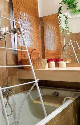 une salle de bain avec une étagère avec des paniers et une baignoire dans l'établissement Appartement les pieds dans l'eau, à Cannes