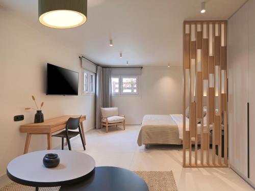 a room with a bed and a desk and a table at Olivia Sports and Sea in Pteleós