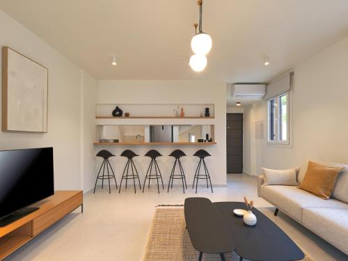 a living room with a couch and a table and stools at Olivia Sports and Sea in Pteleós