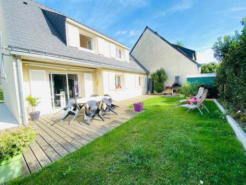 een patio met stoelen en een tafel in de tuin bij Casa Bords de Loire in Mûrs-Érigné