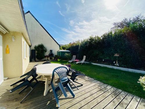een houten terras met een tafel en stoelen erop bij Casa Bords de Loire in Mûrs-Érigné