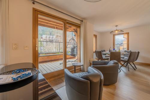 d'un salon avec des chaises et une table ainsi que d'un balcon. dans l'établissement Toluvie Apartment - Snow and Trek, à Morzine