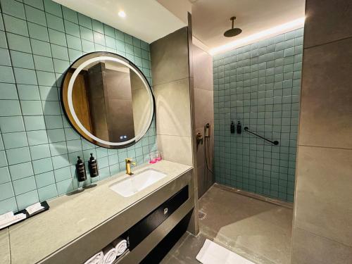 a bathroom with a sink and a shower with a mirror at Ramada Encore by Wyndham Ambala GT Road in Ambāla