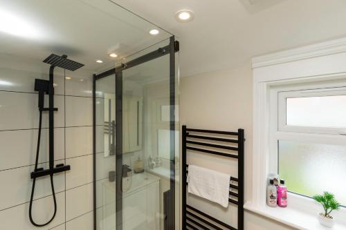a bathroom with a shower with a glass door at Victoria Cottage Seaside - Spacious 4-BR in Bognor Regis,close to Beachfront & 2 minutes from Butlins Holiday Camp in Felpham