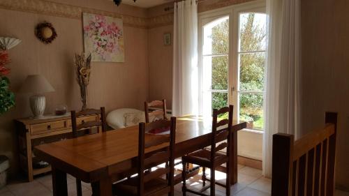 une salle à manger avec une table et des chaises et une fenêtre dans l'établissement Chambres d'hôtes d'Evelyne, à Pluneret