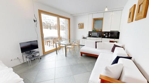 a living room with a white couch and a table at Schweizerhaus Apartments in Maloja