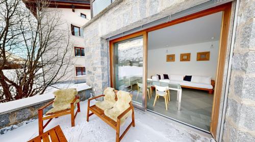 a balcony with two chairs and a table at Schweizerhaus Apartments in Maloja
