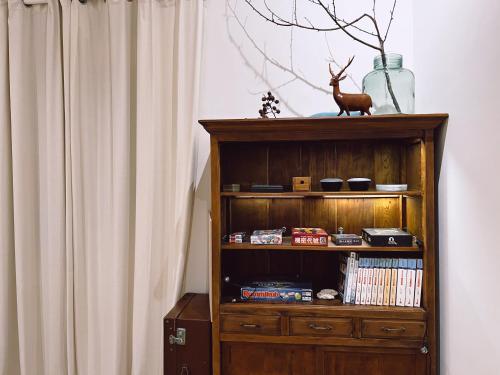 a wooden book shelf next to a curtain at 泊寓 boyü in Lugang