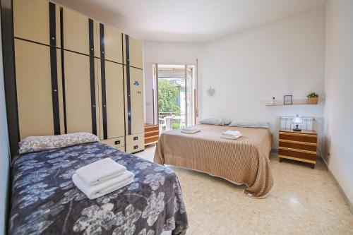 a bedroom with two beds and a large closet at Front Stays Terracina Mare in Terracina