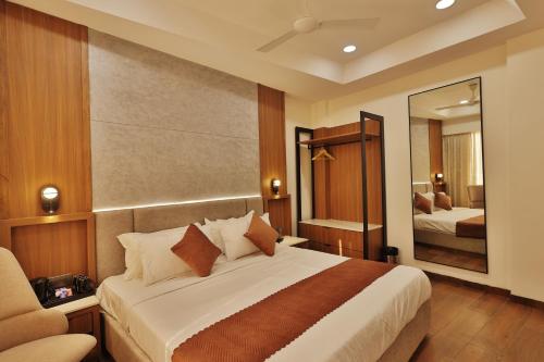 インドールにあるHotel Skyvistaの大きなベッドと鏡のある寝室