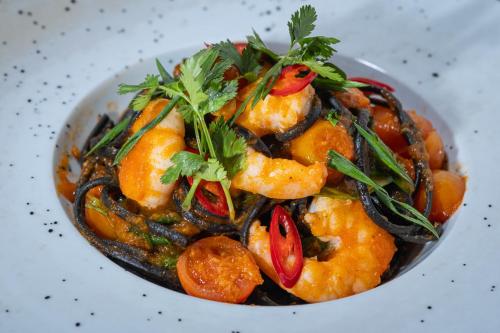 a bowl of food with shrimp and vegetables at Mercure Ponta Delgada Azores in Ponta Delgada
