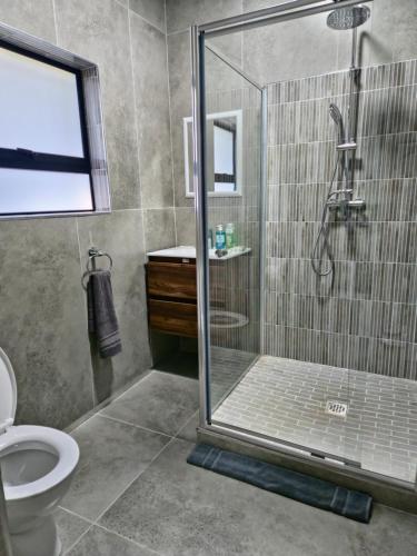 a bathroom with a shower and a toilet at Lagoon View Serenity! in Knysna