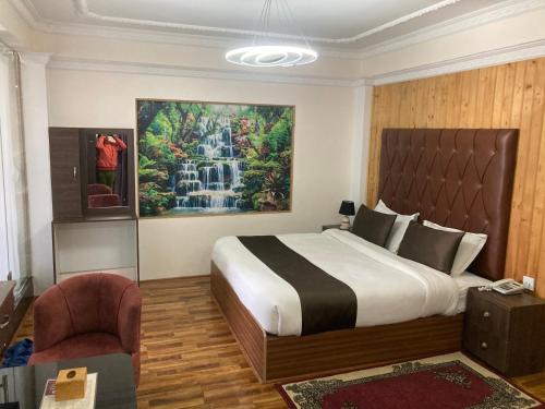 a bedroom with a bed and a painting of a waterfall at Dream Palace Resort in Kathmandu