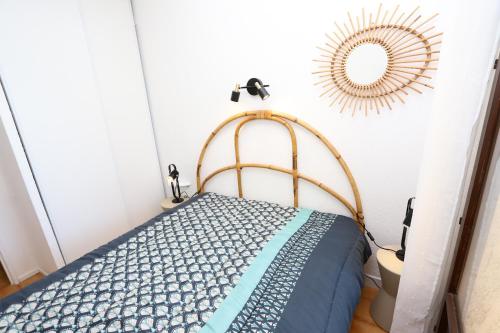 une chambre avec un lit et un miroir au mur dans l'établissement St Cyprien charmant rez de jardin 2 velos Piscine, à Saint-Cyprien