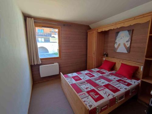 une chambre avec un lit avec des oreillers rouges et une fenêtre dans l'établissement Duplex 2P avec Balcon, Parking et Casiers à Ski - FR-1-504-686, à Uvernet