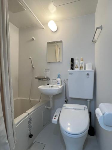 a white bathroom with a toilet and a sink at stay papiyon 博多 in Fukuoka