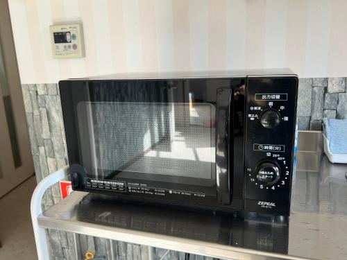 a black microwave sitting on a table at stay papiyon 博多 in Fukuoka
