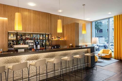 a bar with white stools in a restaurant at NH Düsseldorf City Nord in Düsseldorf
