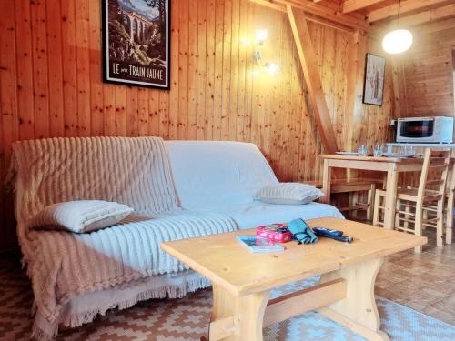 a living room with a couch and a table at Chalet Des Oursons, Capcir Pyrénées Catalanes in Puyvalador