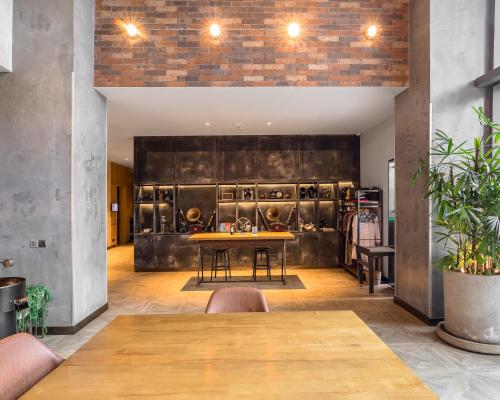 a dining room with a table in front of a wall at The Social House Nairobi, a Preferred Lifestyle Hotel in Nairobi