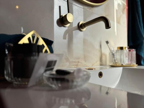 a bathroom sink with a faucet and a mirror at Add'Or, Suite et Spa in Beugny