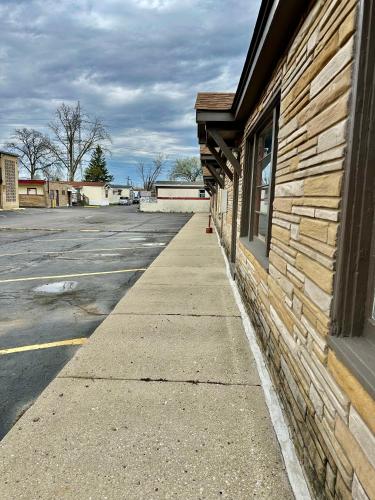 a sidewalk next to a building next to a parking lot at Des Plaines Motel By OYO O'Hare Airport Chicago in Des Plaines